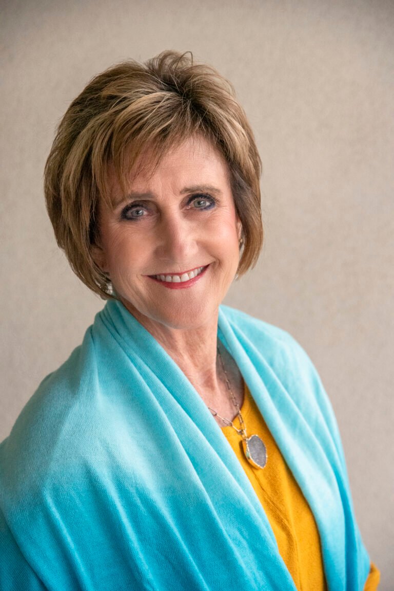 Professional headshot by Laura Voight: smiling woman with short brown hair in a teal top