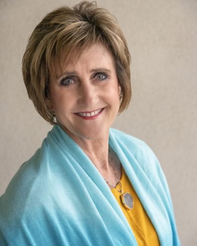 Professional headshot by Laura Voight: smiling woman with short brown hair in a teal top